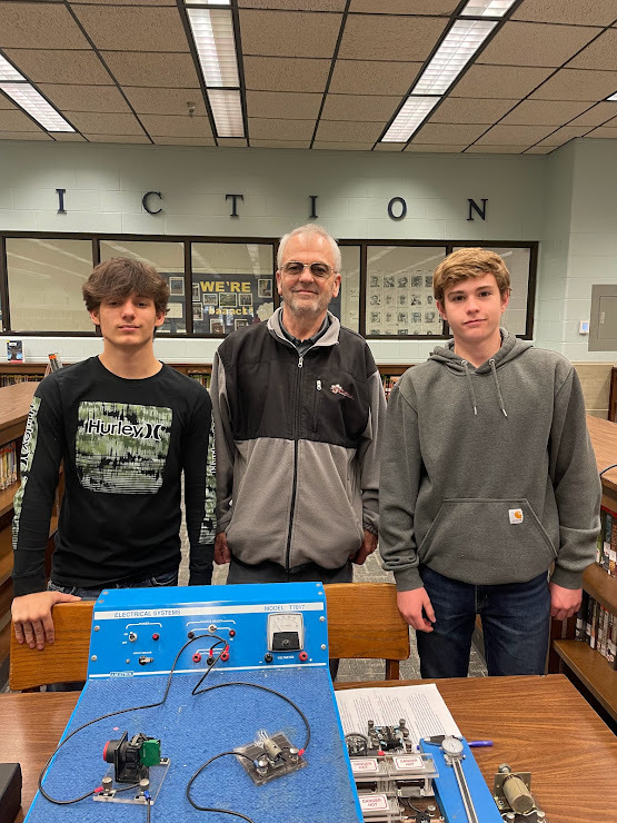 Mr. Hobbs with two Advanced  Manufacturing Students  Levi Singer (far left) and  Garrett Mastin (far right)
